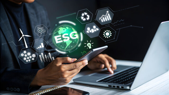Businessman using laptop and mobile phone with esg icons on virtual screen, representing environmental, social, and governance principles for sustainable business