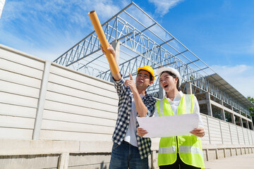 Construction engineers discussing project plans at building site
