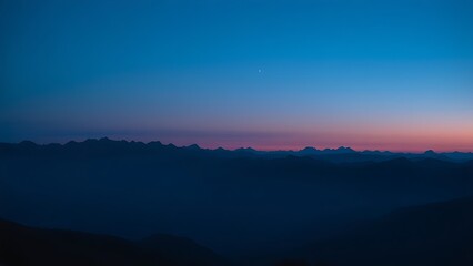Obraz premium Silhouetted mountain range under a blue twilight sky, capturing a panoramic natural landscape.