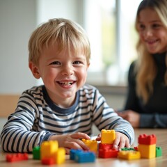 Happy child plays with colorful toy blocks during therapy session. Boy smiles joyfully. Parent or therapist supports learning development indoors. Playful activity promotes engagement and creativity.