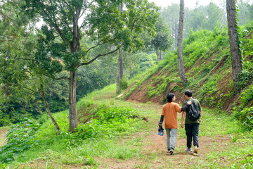 Fototapeta premium Back View Of Friends Enjoying Scenic Hike Together Through Lush Green Forest