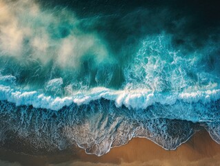 Fototapeta premium Aerial view of churning ocean waves crashing onto a sandy beach with foamy white crests