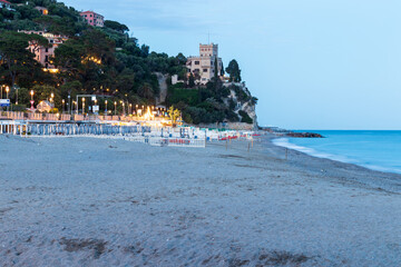 Finale ligure at night san donato castelletto with waves crashing on beach, italy