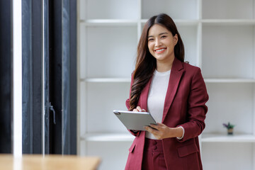 Young asian business professional interacting with tablet smiling