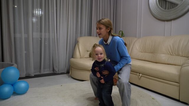 Heartwarming video capturing toddler's developmental journey in cozy home, from tentative first steps with caring adult's support to joyous, active play with blue balloons.