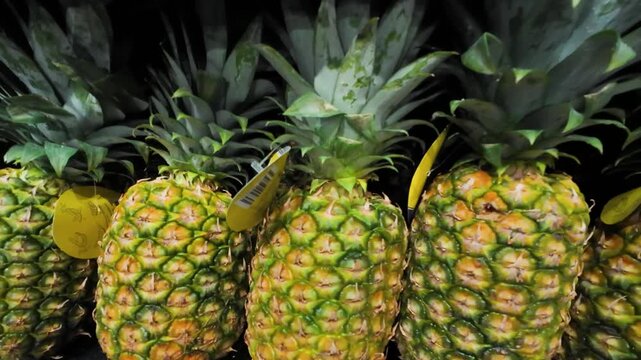Pineapples on a shelf in a supermarket.