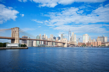 Fototapeta premium Majestic Brooklyn Bridge graces the NYC skyline. Soaring steel arches frame the cityscape, bathed in warm sunlight. Iconic landmark for travel and architecture projects. wallpaper, 4k 