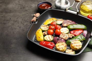Pan with grilled vegetables and spices on grey table, closeup. Space for text