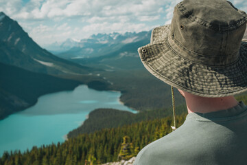 Hiker gazes at a stunning lake surrounded by mountains and lush forests