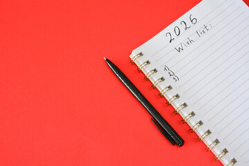 2026 Wish List with Notebook and Pen on red background new year resolution