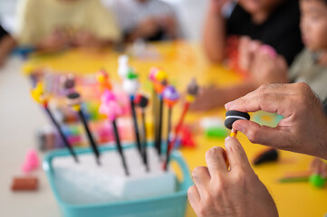 A group of children playing and shaping colorful soft clay in preschool art class, enhancing creativity, imagination, and hand skills through playful education.