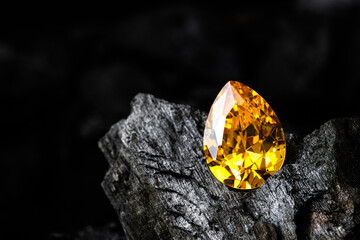 Brilliant yellow gemstone on dark textured rock, symbolizing wealth, success, and elegance, ideal for jewelry design, luxury branding, fashion advertising, and creative projects.