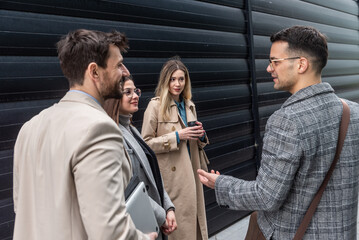IT experts freelance workers innovative technology developers, working on a new project staff meeting with casual talk in formalwear outside office building before the work. Discussing business people