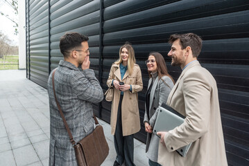 IT experts freelance workers innovative technology developers, working on a new project staff meeting with casual talk in formalwear outside office building before the work. Discussing business people
