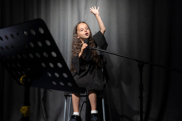 An artistic talented little girl singer takes the top note. An emotional singer and actress performs on stage.