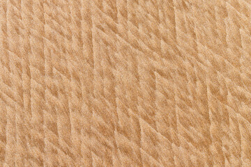 The sea and wind create soft textures in the sand on the beach, a backdrop for presentations.