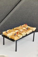 Buffet catering with assorted sandwiches on trays, party finger food and appetizers on a white table at corporate event
Catering buffet with assorted sandwiches on serving trays at event