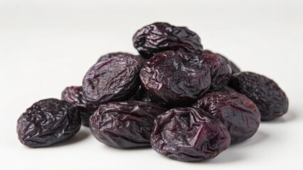 Pile of dried prunes on white background with natural lighting