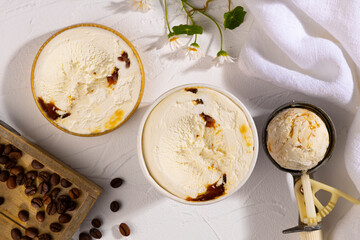 Coffee ice cream tubs on a white background with flowers and coffee beans.