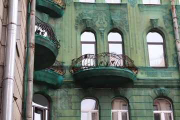 Facade of building covered with green mesh to prevent the plaster from falling off.