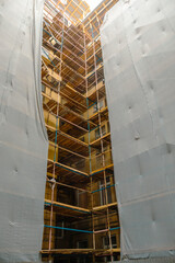 Building with scaffolding and a white sheet covering it