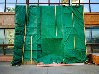 Green tarp is covering entrance in the building.