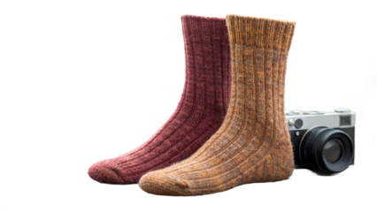 A pair of woolen socks in red and beige with a vintage camera on a black isolated background created with generated ai