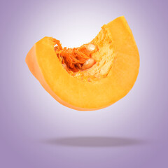 Slice of fresh pumpkin in air against violet background