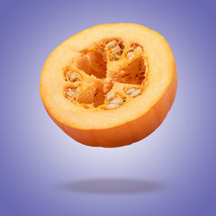 Slice of fresh pumpkin in air against purple blue background