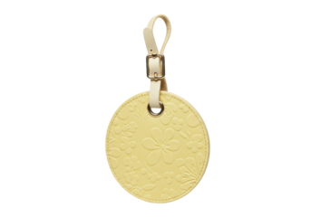 Pale yellow round luggage tag with floral pattern isolated, travel accessory for suitcase or bag identification