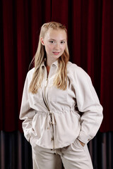 Portrait of a beautiful young female actress in a white suit.