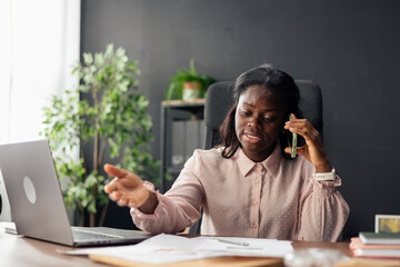 Black businesswoman discussing on phone call and working
