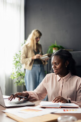 Businesswomen collaborating on project at modern office