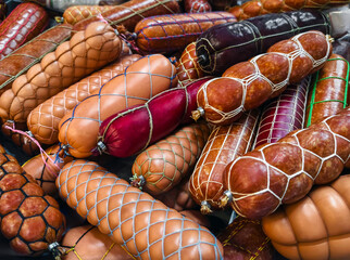 Various types of sausages displayed in a market setting during a vibrant food festival