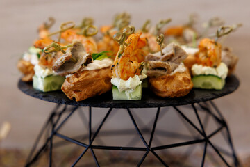 Assorted Savory Eclairs with Meat, Salmon and Cream Cheese on Catering Table