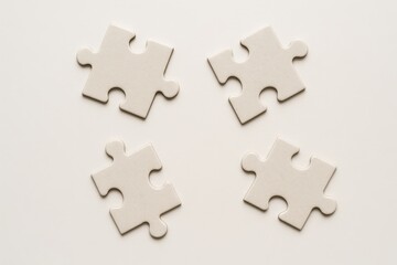 Fototapeta premium Simple composition of four puzzle pieces on a table surface as a concept of problem solving, creativity, and leisure activity, background
