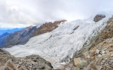 Monte Rosa (Italy) - A mountains view in Valsesia with Monte Rosa mount peak of Alps, alpinistic paths to Rifugio Modena and Capanna Margherita refuge, with snow glacier and alpinists.