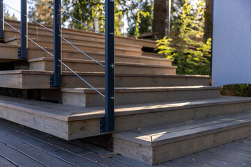 Obraz premium Beautifully Crafted Wooden Steps Surrounded by Nature, Showcasing the Graceful Design of a Modern Outdoor Staircase with Natural Elements and Stylish Railings