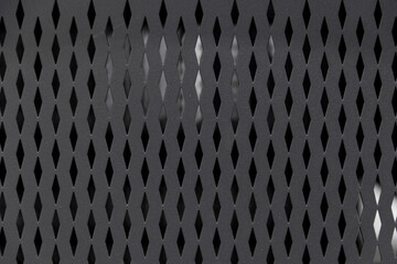 Close-Up of a Unique Black Metallic Grille Design Featuring a Distinctive Pattern that Adds Sophistication and Functionality to Modern Devices and Appliances