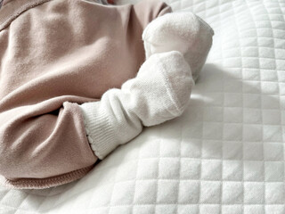 Softly clad infant foot emerges from cozy fabric, showcasing delicate textures and gentle movement in a serene environment, capturing the essence of early childhood moments