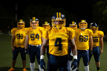 Fototapeta premium Football player with team on field at night