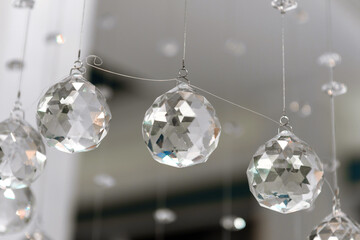 Faceted sparkling balls are hanging. Glass multi-faceted decoration.