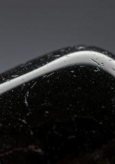 Close Up of Wet Black Stone with Water Droplets on Rough Surface