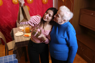 Girl receives birthday presents. Soft lighting.