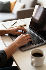Fototapeta premium Close-up of a doctor’s hands typing on a laptop at a clean, modern medical office desk. Digital healthcare, telemedicine, and medical documentation concept.