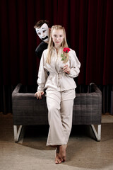 A mime in love and a girl with a rose on a theater stage. Close-up.
