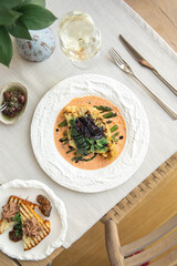 Cauliflower steak with asparagus and sauce on white plate