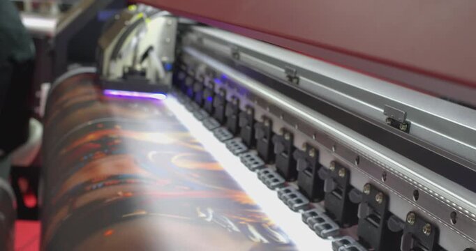 Large format printer printing a colorful image on white vinyl