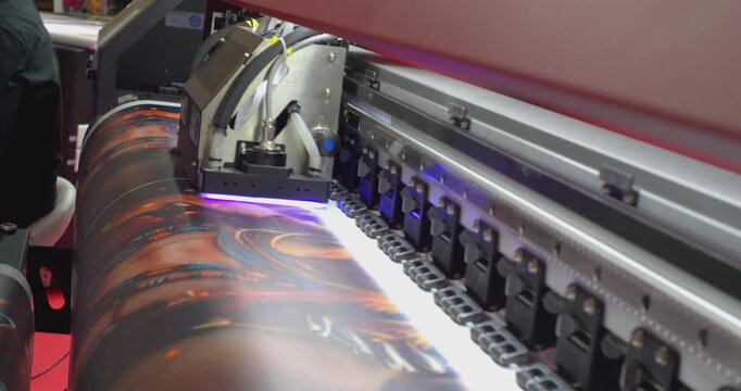 Large format printer printing a colorful image on white vinyl