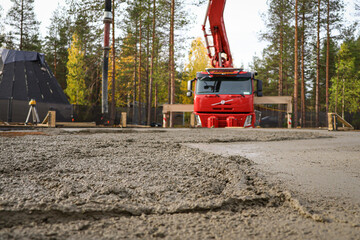 Concrete foundation slab pouring at construction site with pump truck